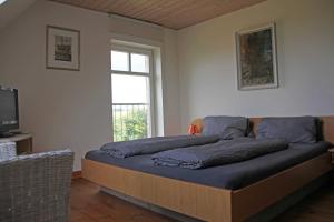 a bedroom with a bed with blue sheets and a window at Ferienhaus Polkvitz in Marlow