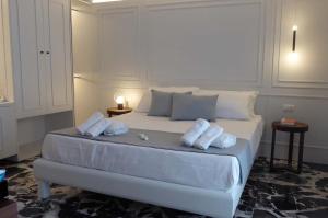 a bedroom with a white bed with towels on it at Paderagi in Santa Domenica