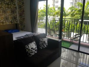 łóżko i kanapa w pokoju z balkonem w obiekcie 01-AustinRegency homestay Studio family room 4pax near Toppen Aeon Tebrau w mieście Johor Bahru