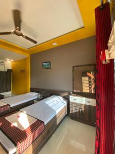 a room with two beds and a mirror at APURBA GUEST HOUSE in Jorhāt