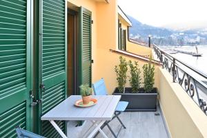a balcony with a table and potted plants at LakeSweetLakeComo in Como