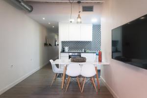 cocina con mesa blanca y sillas blancas en Modern Catalan Apartments by Olala Homes, en Hospitalet de Llobregat