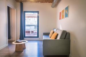 sala de estar con sofá y mesa en Modern Catalan Apartments by Olala Homes, en Hospitalet de Llobregat