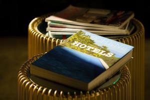 a stack of books in a gold wicker basket at Birkin Porto 1870 in Cagliari