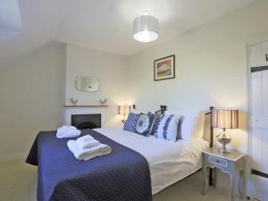 a bedroom with a bed with towels on it at Piglet Cottage. A well equipped home from home. in Uggeshall