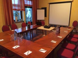 a conference room with tables and chairs and a screen at Hotel Laacher Lay in Mendig