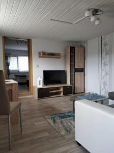 uma sala de estar com um sofá e uma televisão em Ferienwohnung Reiter em Ummanz