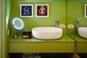 een groene badkamer met een wastafel en een spiegel bij Birkin Porto 1870 in Cagliari