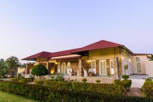 una casa con techo rojo y patio en Astroport Sariska "Treetop" by Eight Continents en Tehla