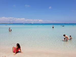 a group of people in the water at the beach at Blue Lovely House in San Vito lo Capo