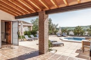un patio al aire libre con sillas y una piscina en Cortijo Cantares, en Málaga