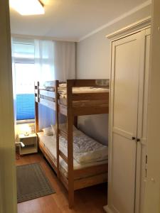 two bunk beds in a room with a window at Vier Jahreszeiten 2-6 in Großenbrode