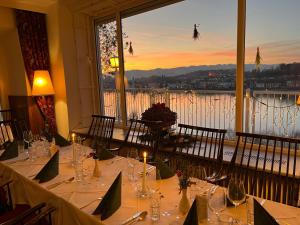 een eetkamer met een tafel en uitzicht op de stad bij Hotel-Restaurant Faustschlössl in Feldkirchen an der Donau