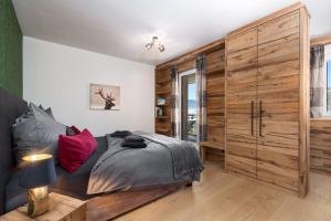 een slaapkamer met een bed en een grote houten kast bij Buccara Panoramasuite Brixental - Brixen im Thale in Brixen im Thale
