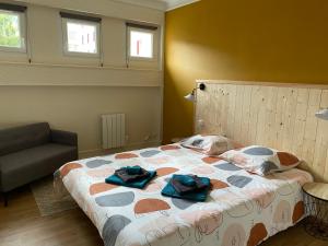 a bedroom with a bed and a chair and windows at les Hallettes du havre hyper centre 300 de la mer in Le Havre