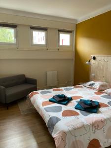 a bedroom with a bed and a couch and windows at les Hallettes du havre hyper centre 300 de la mer in Le Havre