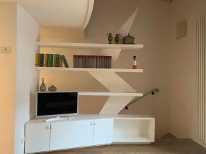 a living room with a tv on a white cabinet at La casetta rossa in Rimini