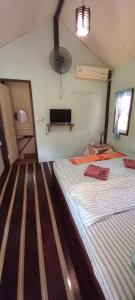 a bedroom with a bed and a tv in it at Eco Bungalow in Ko Phayam