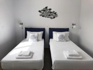 two beds sitting next to each other in a room at Bay View Villas in Methoni