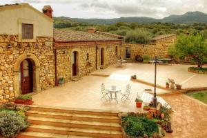 a stone house with a patio and a table and chairs at Le Querce di Cota in Troina