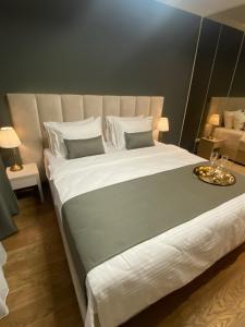 un grande letto con lenzuola e cuscini bianchi in una stanza di BW Sky View Belgrade Waterfront a Belgrado