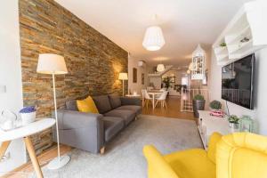 uma sala de estar com um sofá e uma parede de tijolos em Sé Guesthouse em Braga