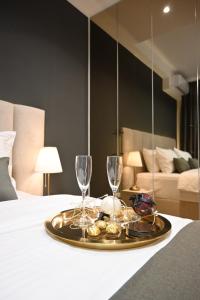a tray with wine glasses and cookies on a bed at BW Sky View Belgrade Waterfront in Belgrade