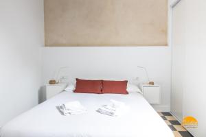 ein Schlafzimmer mit einem weißen Bett mit zwei Handtüchern darauf in der Unterkunft La Casa del Alfarero by Cadiz Time in Cádiz