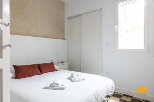 ein weißes Schlafzimmer mit einem Bett mit Handtüchern darauf in der Unterkunft La Casa del Alfarero by Cadiz Time in Cádiz