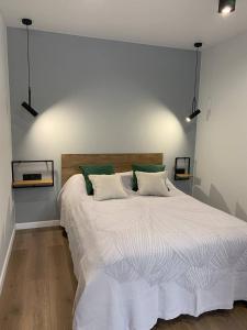 a bedroom with a large white bed with green pillows at Апартаменти в центрі Тернополя in Ternopil