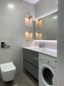 a bathroom with a washing machine and a sink at Апартаменти в центрі Тернополя in Ternopil +17 photos