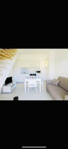 ein Wohnzimmer mit einem weißen Tisch und einem Sofa in der Unterkunft Casa Silvia Climatizzata, giardino privato e posto auto privato in Viddalba