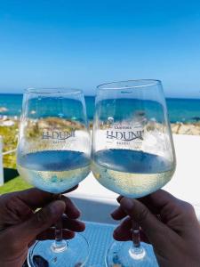 zwei Personen, die ein Glas Weißwein hochhalten in der Unterkunft Casa Silvia Climatizzata, giardino privato e posto auto privato in Viddalba