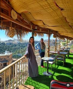 een man en een vrouw op een balkon bij Al Misfah Hospitality Inn in Misfāh