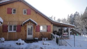 una casa in legno con la neve sul davanti di L'ATELIER, chalet 3* a Vecoux