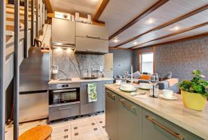 a kitchen with stainless steel appliances and a living room at Zaļais Stūrītis in Liepāja