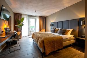 a hotel room with a bed and a desk at Maashof in Venlo