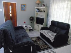 a living room with a couch and a chair at Marnalé Oornagwoonstel in Piet Retief