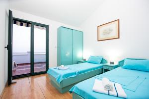 two beds in a room with a view of the ocean at Vila Il Pescatore in Petrovac na Moru