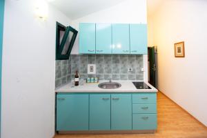 a kitchen with blue cabinets and a sink at Vila Il Pescatore in Petrovac na Moru