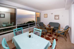 a room with a balcony with a table and chairs at Vila Il Pescatore in Petrovac na Moru