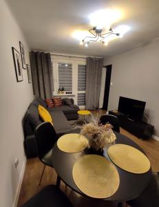 uma sala de estar com um sofá, uma mesa e cadeiras em Apartament Krzemyk em Sandomierz