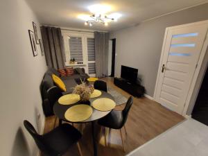 uma sala de estar com uma mesa e um sofá em Apartament Krzemyk em Sandomierz