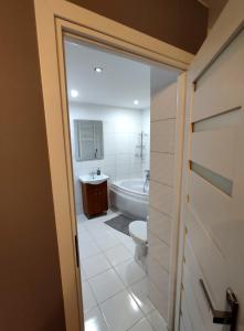 uma casa de banho com uma banheira, um WC e um lavatório. em Apartament Krzemyk em Sandomierz