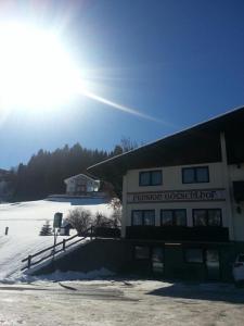 ein Gebäude im Schnee mit der Sonne dahinter in der Unterkunft Götschlhof in Schladming