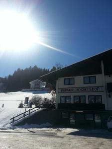 a building in the snow with the sun behind it at Götschlhof in Schladming
