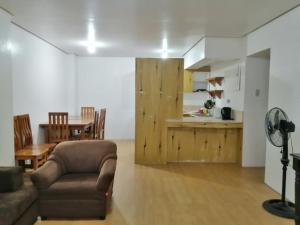 a living room with a couch and a table and a kitchen at The Half House by Elmar Cabin in Baguio