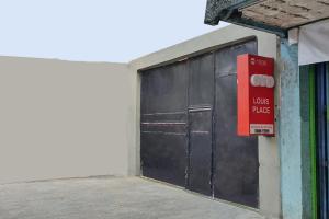 uma grande porta de garagem preta com uma caixa vermelha em Capital O 1898 Louise Place em Cianjur