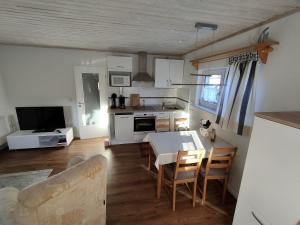 a kitchen and living room with a table and chairs at Ferienhaus "Sommerbrise" in Gager
