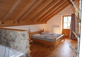 um quarto com uma cama num quarto com tectos em madeira em Charmante Ferienwohnung für Pärchen em Kašperské Hory
